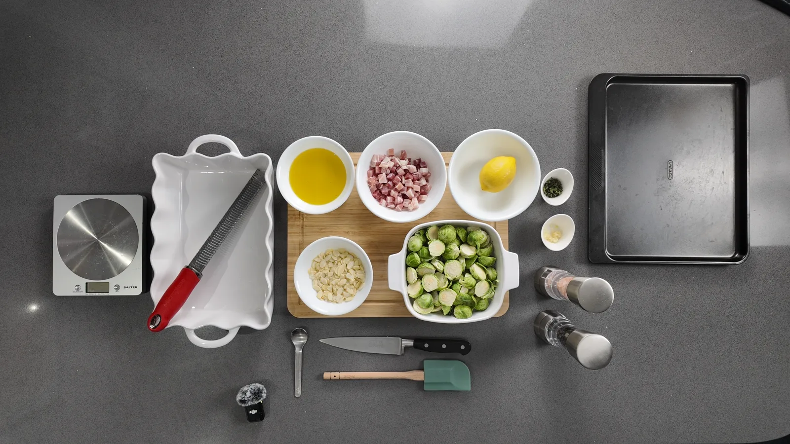 Ingredients, scales, knives and dishes laid out from above on a grey worktop before a Keto & Clarity recipe is filmed