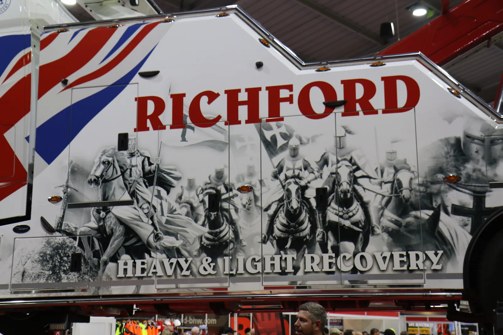 Close-up of a Richford recovery truck body painted with a monochrome battle scene, Union Jack stripes and the words Heavy & Light Recovery.