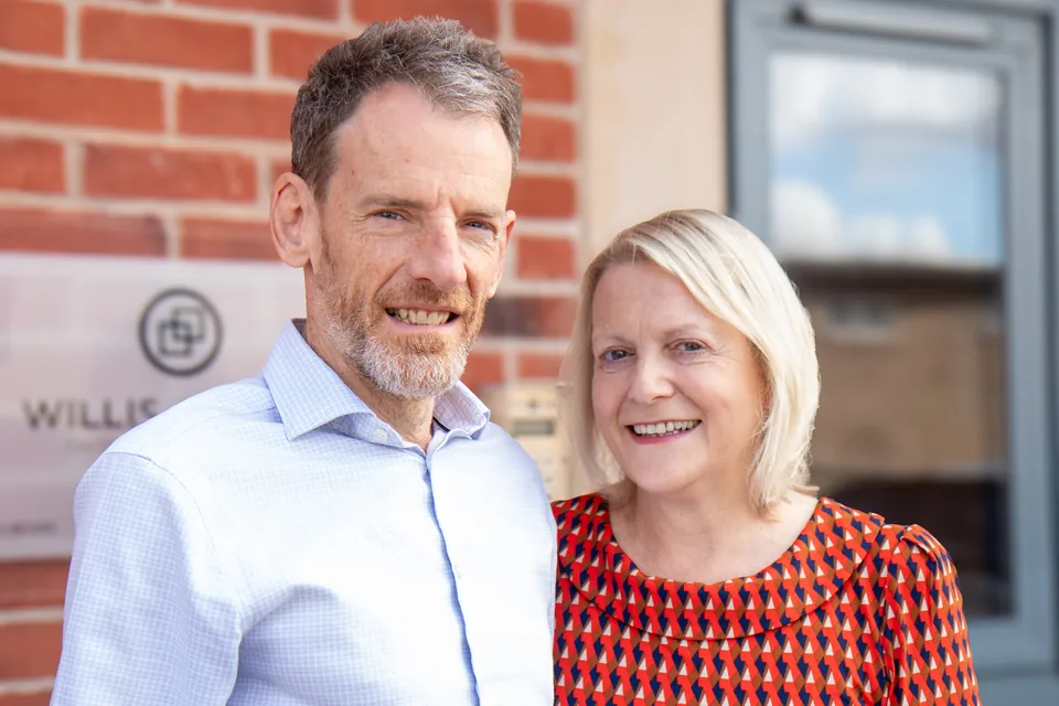 Robert and Julie from Willis Cooper smiling outside the practice's office in Belper